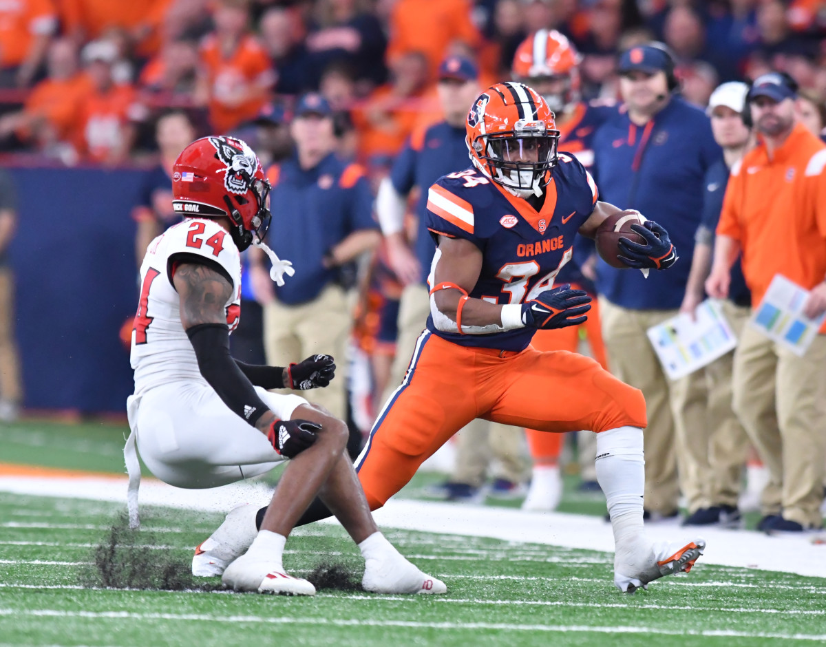 Syracuse RB #34 Sean Tucker makes a move against the NC State defender (#24 Derrek Pitts Jr.) 