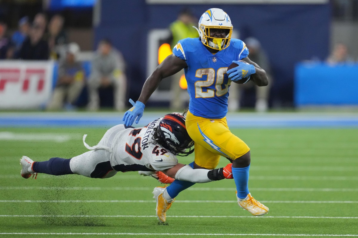 Los Angeles Chargers running back Sony Michel (20) carries the ball against Denver Broncos linebacker Alex Singleton (49) in the second half at SoFi Stadium.