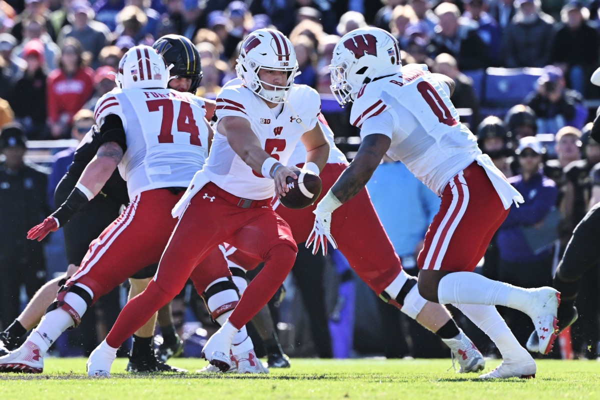 Oct 8, 2022; Evanston, Illinois, USA; Wisconsin Badgers quarterback Graham Mertz (5) hands off the ball during a game against the Northwestern Wildcats at Ryan Field.