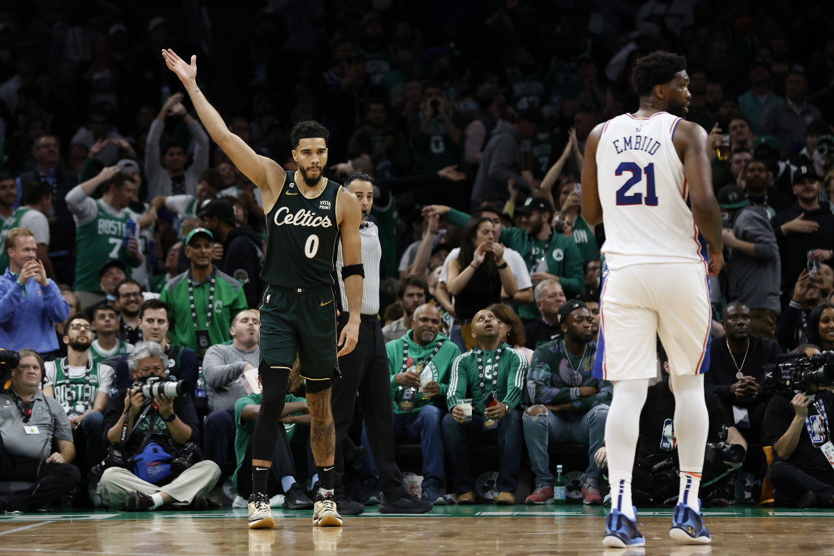 Boston Celtics forward Jayson Tatum (0) acknowledges the crowd as Philadelphia 76ers center Joel Embiid (21) looks away during the fourth quarter at TD Garden.