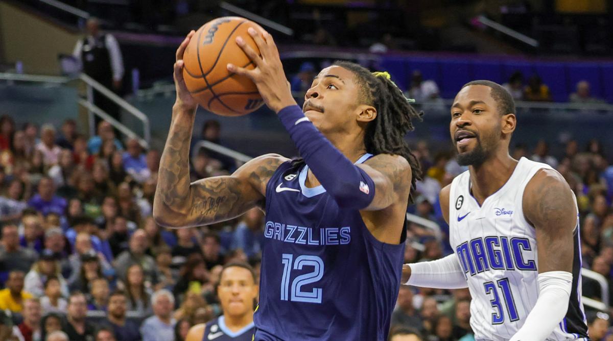 Oct 11, 2022; Orlando, Florida, USA; Memphis Grizzlies guard Ja Morant (12) goes to the basket in front of Orlando Magic guard Terrence Ross (31) during the second half at Amway Center.