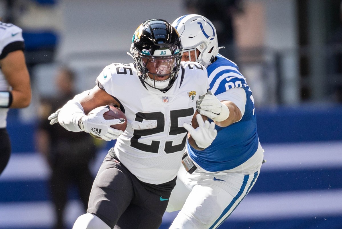 Oct 16, 2022; Indianapolis, Indiana, USA; Jacksonville Jaguars running back James Robinson (25) runs the ball while Indianapolis Colts defensive tackle Grover Stewart (90) defends in the first quarter at Lucas Oil Stadium.