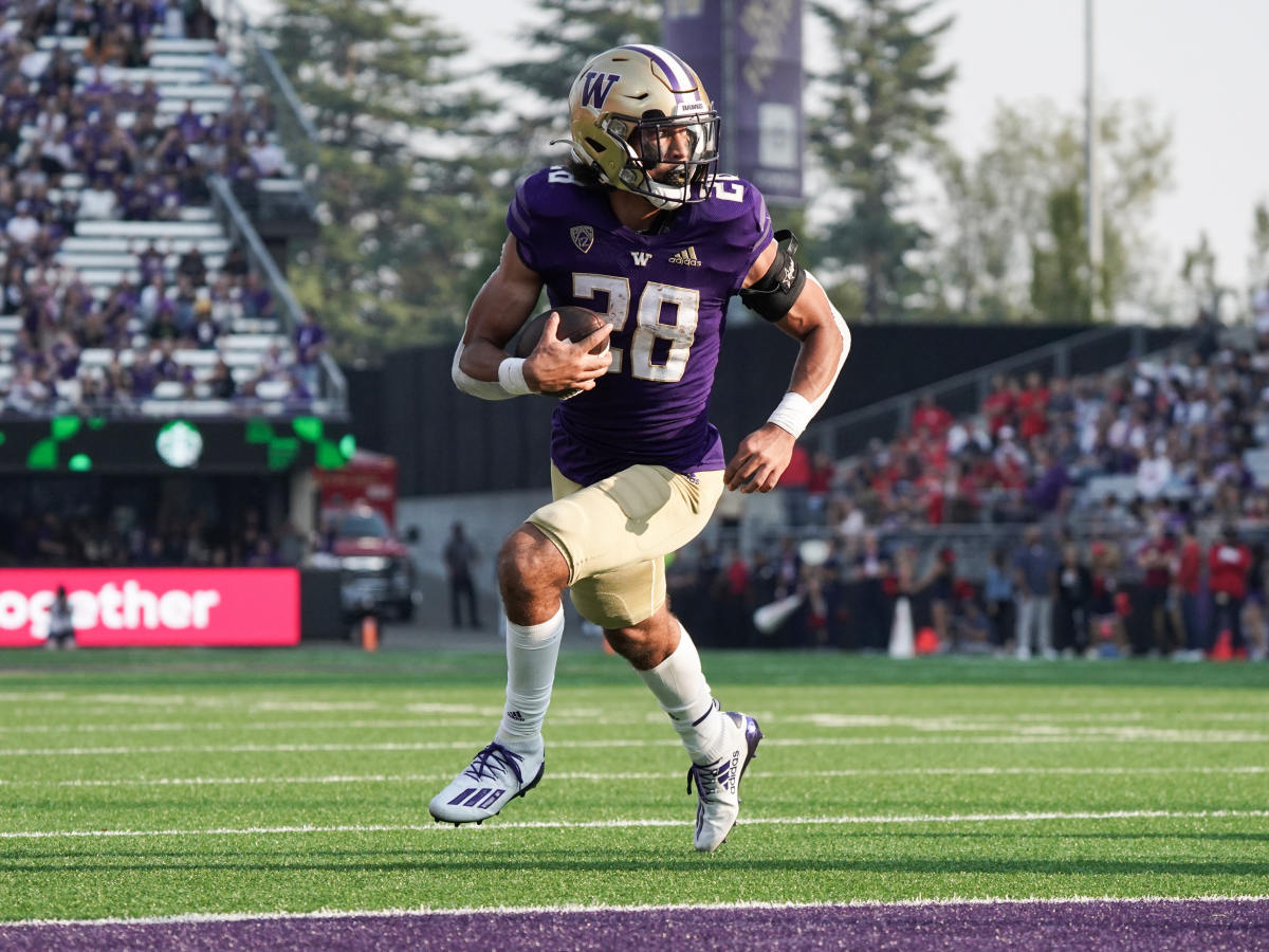 Sam Adams turns up field on a 4-yard pass to score his first Husky touchdown.