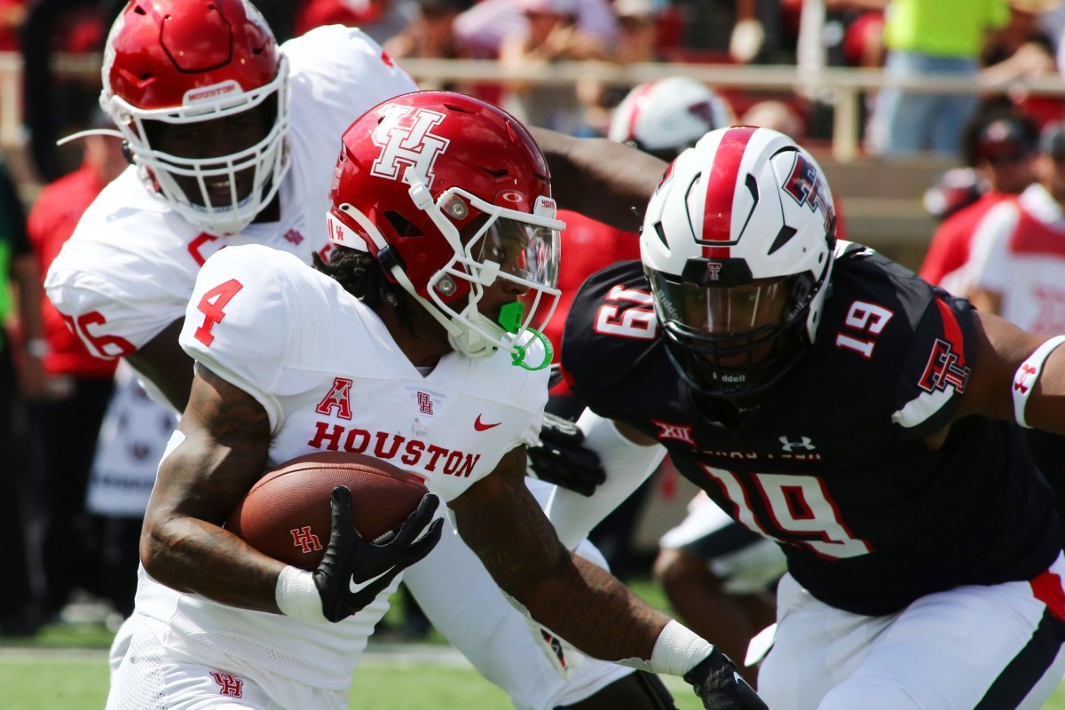 Sep 10, 2022; Lubbock, Texas, USA; Houston Cougars running back Ta Zawn Henry (4) rushes against Texas Tech Red Raiders defensive back Tyree Wilson (19) in the first half at Jones AT&T Stadium and Cody Campbell Field.