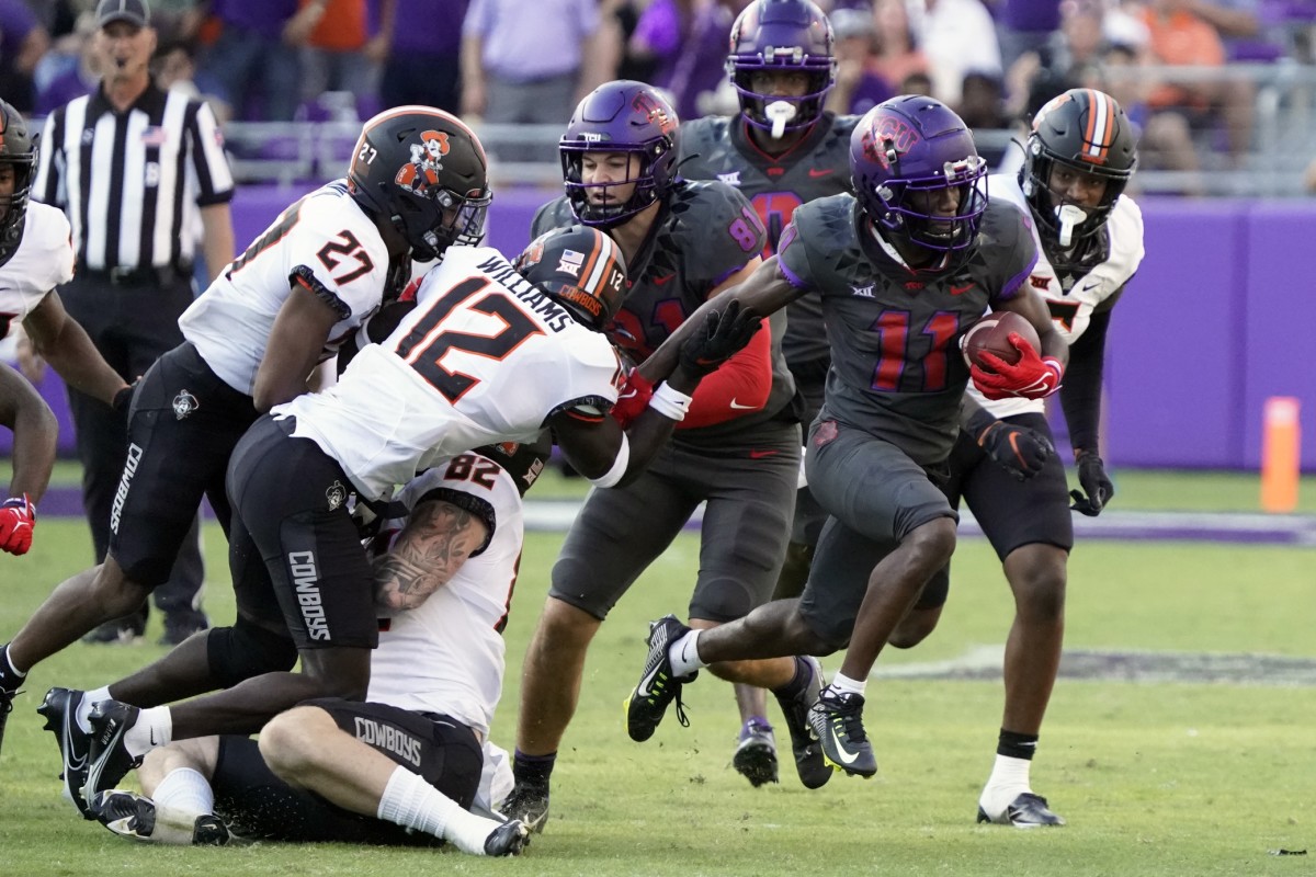 TCU Horned Frogs punter returner Derius Davis (11) runs past Oklahoma State Cowboys safety Kanion Williams (12) during the second half at Amon G. Carter Stadium.