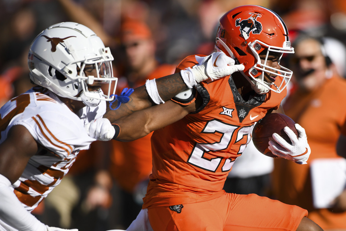 Texas defensive back Jahdae Barron attempts to stop Oklahoma State running back Jaden Nixon.