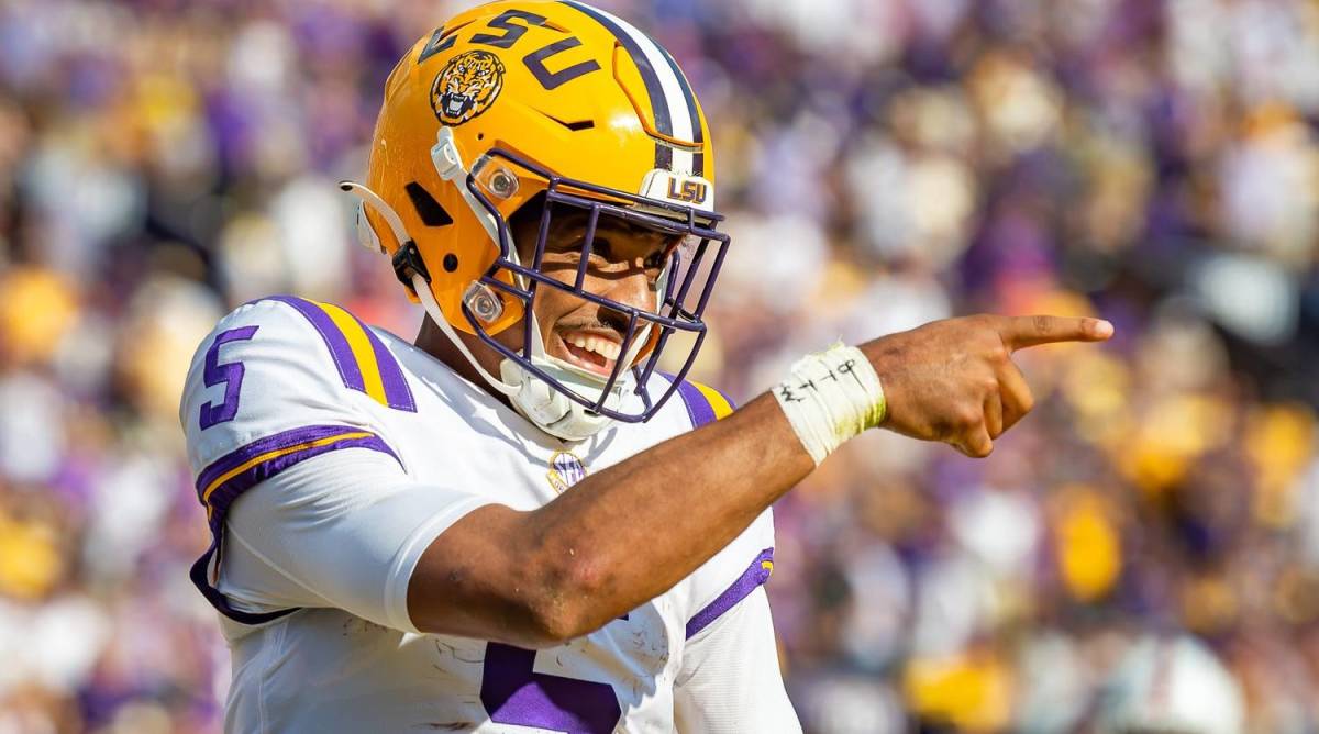 LSU quarterback Jayden Daniels points to the sideline while smiling in a game vs. Ole Miss.