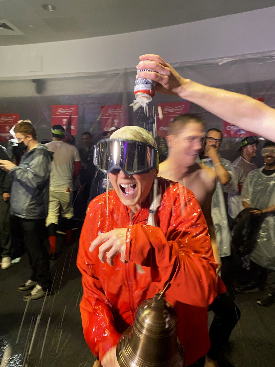 Sheree McMullen holds the Phillies’ liberty bell as she gets drenched with beer during the team’s celebration after clinching a trip to the World Series.