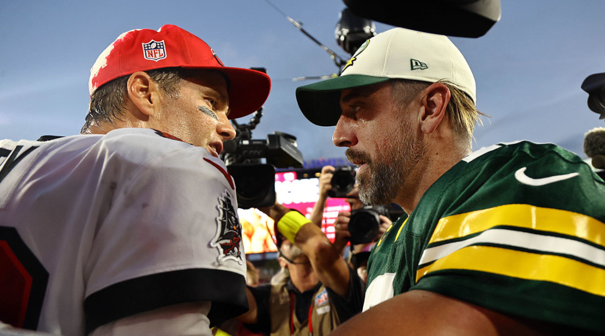 Tom Brady and Aaron Rodgers talk to each other at midfield after a game between the Buccaneers and Packers.