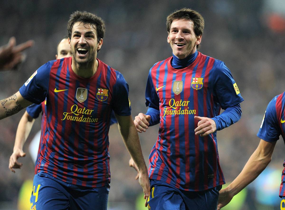 Cesc Fabregas (left) and Lionel Messi pictured playing together for Barcelona in 2012