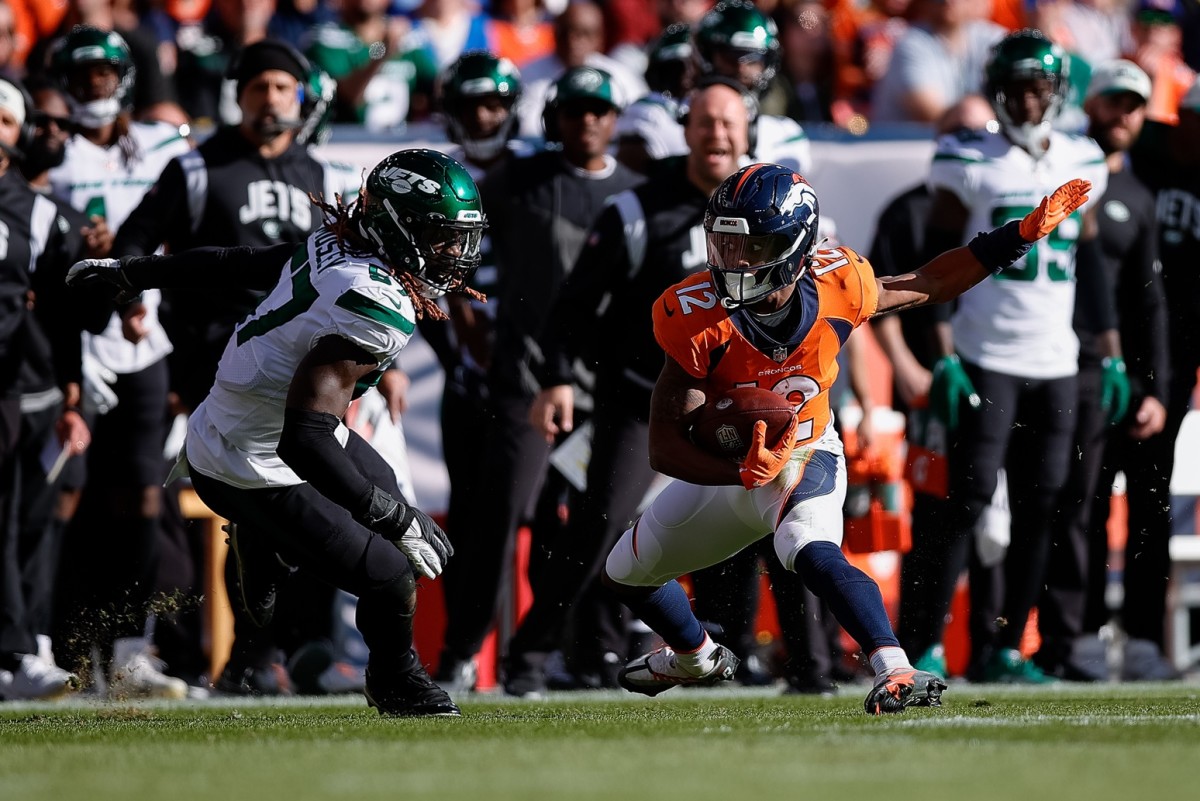Denver Broncos wide receiver Montrell Washington (12) runs the ball under pressure from New York Jets linebacker C.J. Mosley (57) in the second quarter at Empower Field at Mile High.