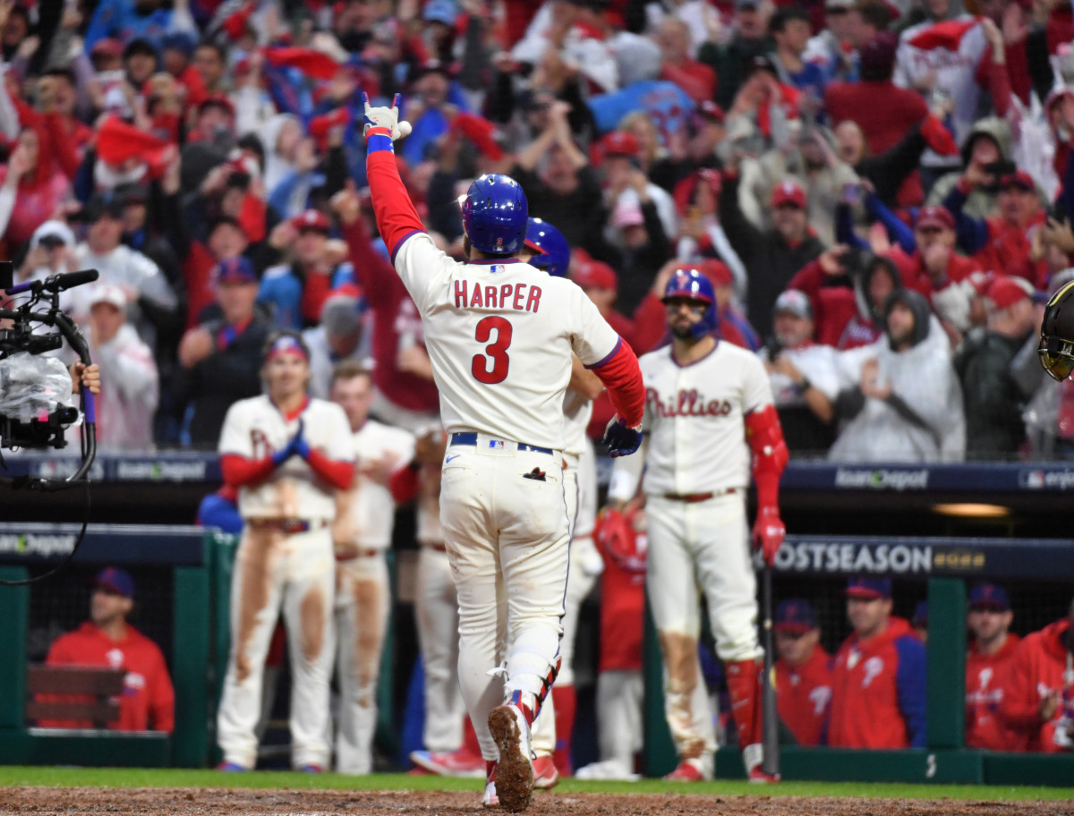Phillies star Bryce Harper holds his hand in the air in celebration
