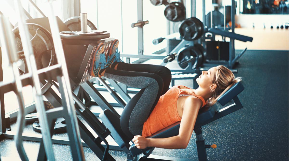 Sporty lady workout legs extension push machine in fitness gym. Woman in  sportswear exercising legs in sports center, healthy lifestyle. Sport  training and weight working out concept. Copy text space Stock Photo |