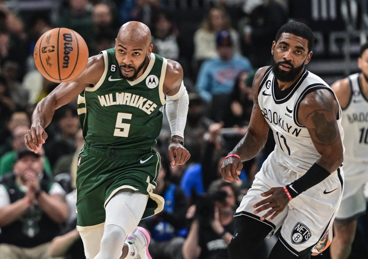 Milwaukee Bucks guard Jevon Carter (5) and Brooklyn Nets guard Kyrie Irving (11) chase a loose ball