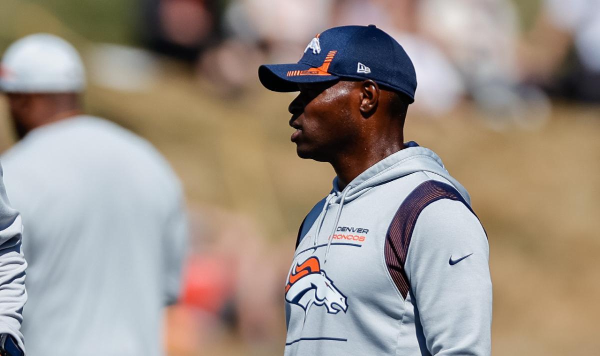 Denver Broncos defensive line coach Marcus Dixon (L) talks with defensive coordinator Ejiro Evero (R) during training camp at the UCHealth Training Center.