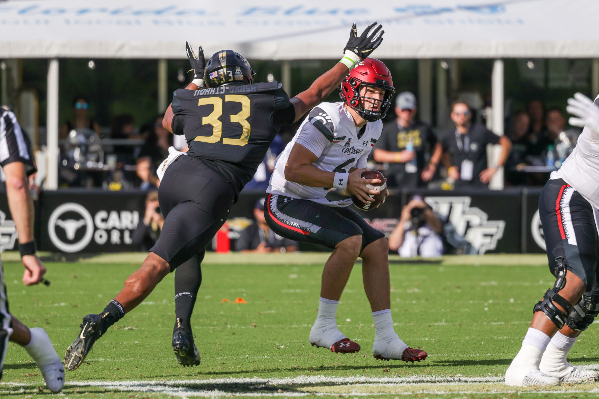 Oct 29, 2022; Orlando, Florida, USA; UCF Knights defensive lineman Tre'mon Morris-Brash (33) moves in for the sack against Cincinnati Bearcats quarterback Ben Bryant (6) during the first quarter at FBC Mortgage Stadium. Mandatory Credit: Mike Watters-USA TODAY Sports