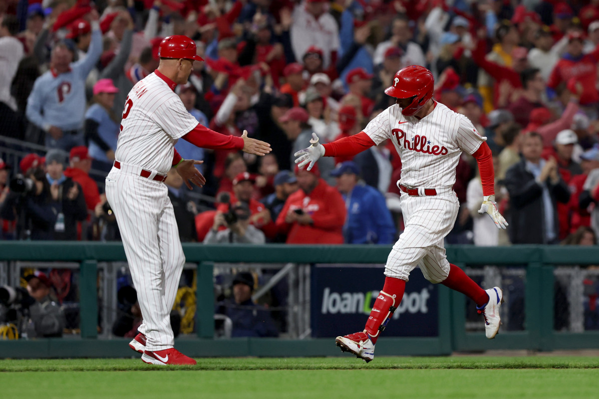 Phillies first baseman Rhys Hoskins shakes hands with third base coach Dusty Wathan after hitting a home run.