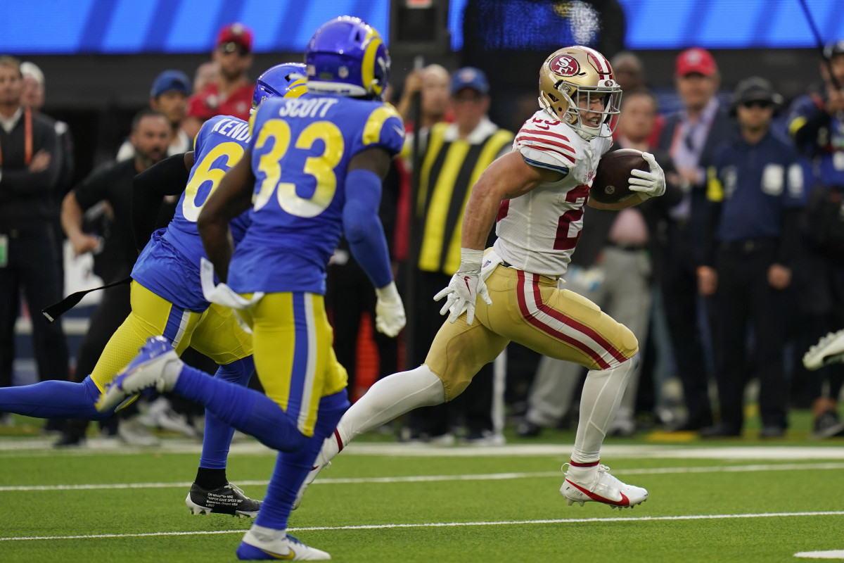 Christian McCaffrey eludes two tackles on a run for the Niners.