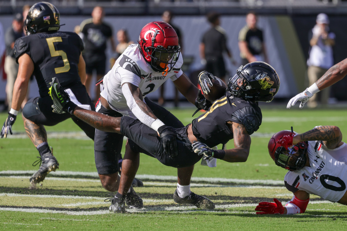Oct 29, 2022; Orlando, Florida, USA; UCF Knights wide receiver Ryan O'Keefe (4) is tackled by Cincinnati Bearcats safety Ja'von Hicks (3) during the first quarter at FBC Mortgage Stadium. Mandatory Credit: Mike Watters-USA TODAY Sports