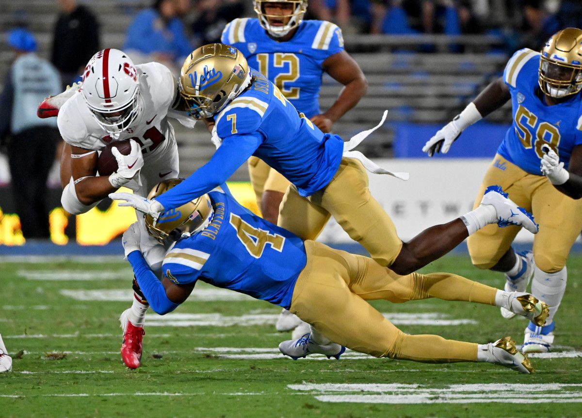 Stanford Cardinal running back Caleb Robinson (21) is stopped by UCLA Bruins defensive back Stephan Blaylock (4) and defensive back Mo Osling III (7) in the first half at the Rose Bowl