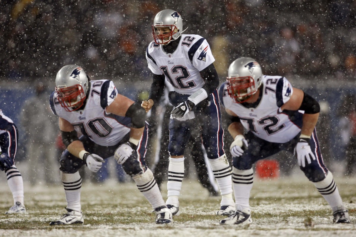 Dec 12, 2010; Chicago, IL, USA; New England Patriots quarterback Tom Brady (12) calls for the snap while protected by linemen Logan Mankins (70) and Matt Light (72) during the game against the Chicago Bears at Soldier Field.