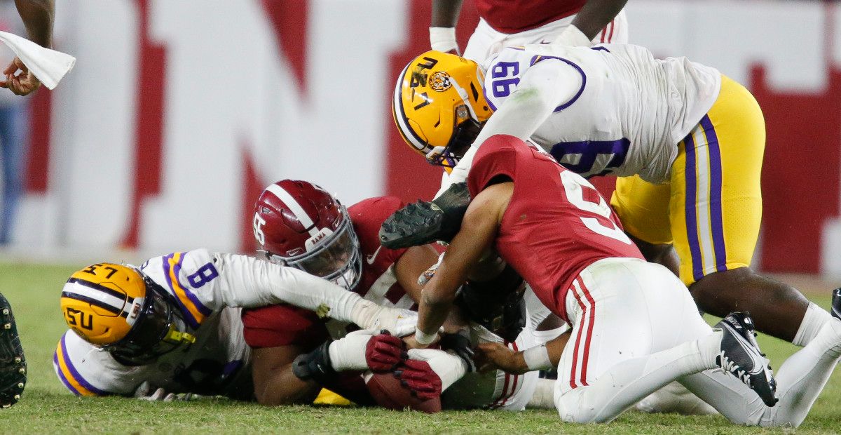 LSU Tigers defensive lineman Jaquelin Roy (99) and defensive end BJ Ojulari (8) battle for a fumble by Alabama Crimson Tide quarterback Bryce Young (9) at Bryant-Denny Stadium. Alabama won 20-14.