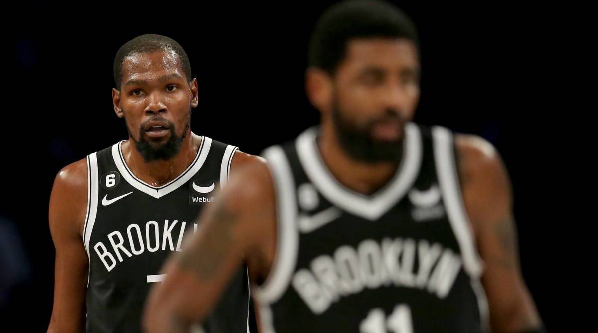 Nets star forward Kevin Durant walks behind point guard Kyrie Irving in the middle of a game vs. the New Orleans Pelicans.