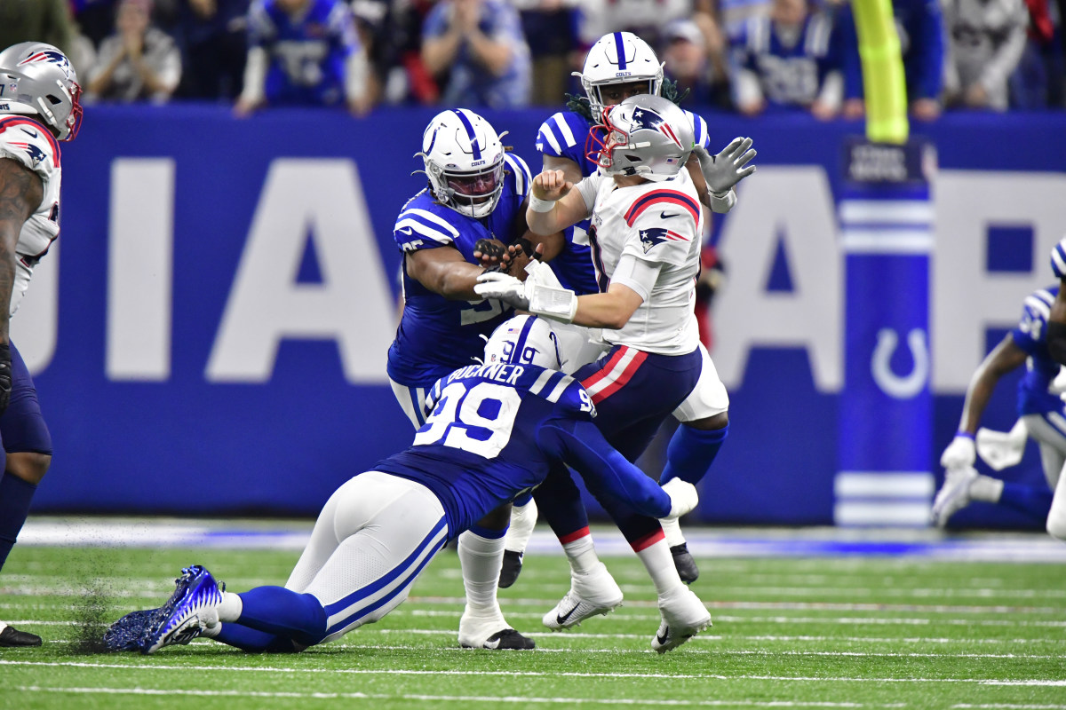 Dec 18, 2021; Indianapolis, Indiana, USA; New England Patriots quarterback Mac Jones (10) is hit hard by multiple Indianapolis Colts during the second half at Lucas Oil Stadium. Colts won 27-17. Mandatory Credit: Marc Lebryk-USA TODAY Sports