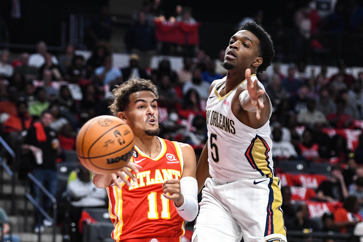Oct 14, 2022; Birmingham, Alabama, USA; Atlanta Hawks guard Trae Young (11) makes a pass under the basket against with New Orleans Pelicans forward Herbert Jones (5) defending in the first quarter at Legacy Arena at BJCC. Mandatory Credit: Larry Robinson-USA TODAY Sports