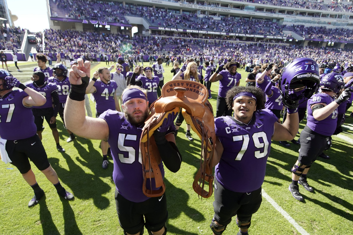 TCU Horned Frogs offensive lineman Alan Ali (56) and center Steve Avila (79) hold the Saddle Trophy following a game against the Texas Tech Red Raiders at Amon G. Carter Stadium.