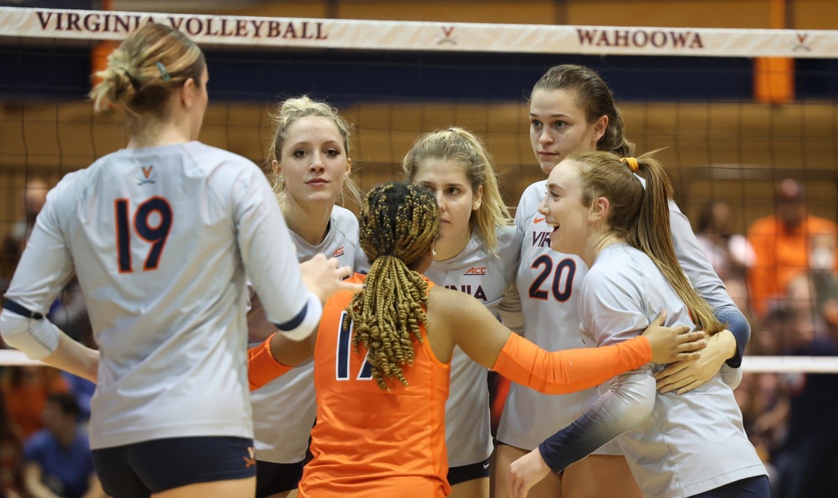 The Virginia Cavaliers volleyball team huddles during its match against the Louisville Cardinals at Memorial Gymnasium.
