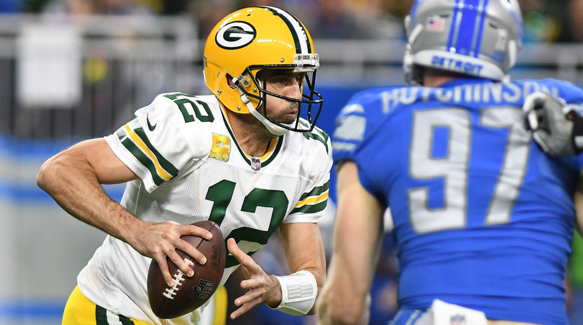 Aaron Rodgers puffs his cheeks out as he looks for somewhere to put the football against the Lions.