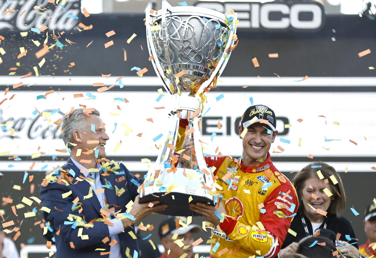 NASCAR President Steve Phelps presents the Bill France NASCAR Cup Series Championship trophy to Joey Logano in victory lane after Logano won the 2022 championship at Phoenix Raceway on  Sunday. (Photo by Sean Gardner/Getty Images)