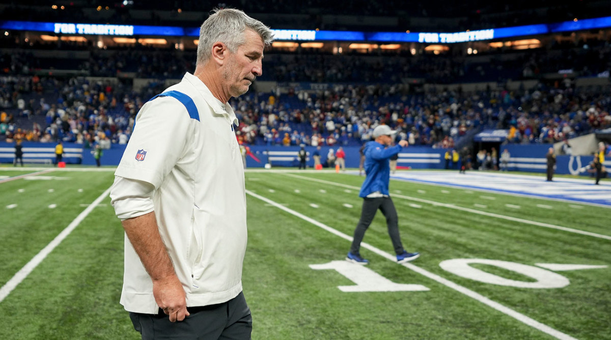 Frank Reich walks off the field with his head down.
