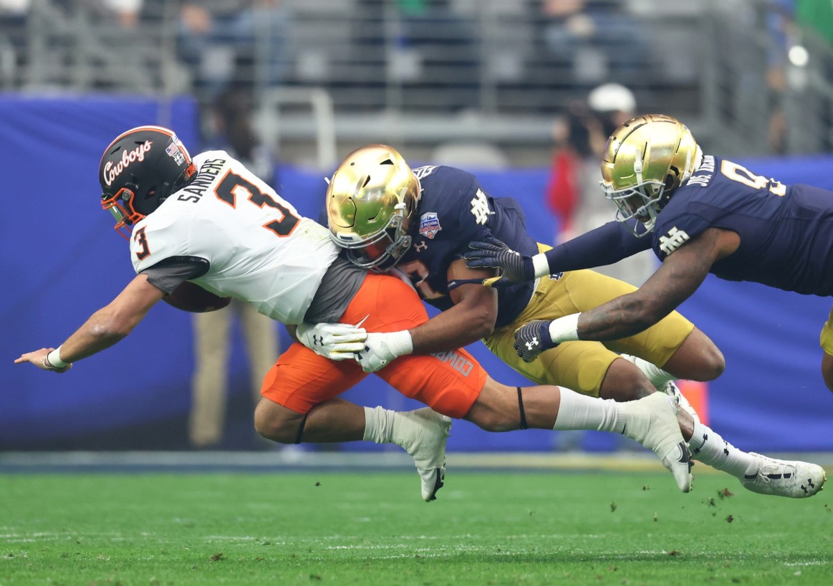 Jan 1, 2022; Glendale, Arizona, USA; Oklahoma State Cowboys quarterback Spencer Sanders (3) is tackled by Notre Dame Fighting Irish defensive lineman Isaiah Foskey (7) in the first half during the 2022 Fiesta Bowl at State Farm Stadium. Mandatory Credit: Mark J. Rebilas-USA TODAY Sports