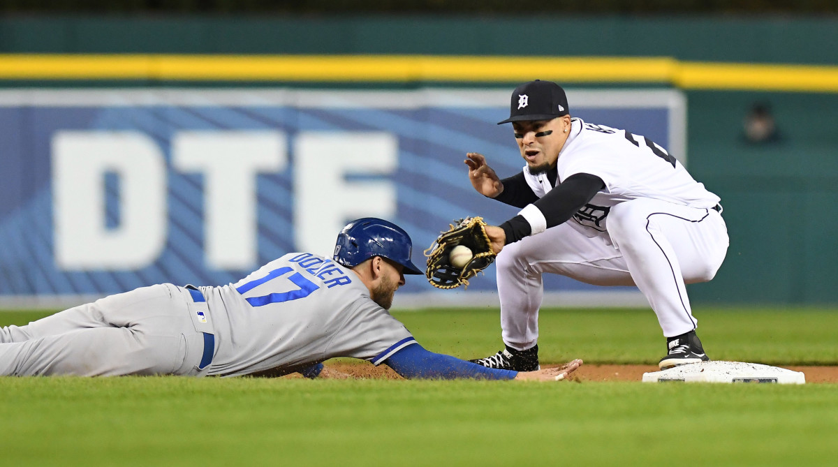 Tigers shortstop Javier Baez tries to tag out Royals baserunner Hunter Dozier on a pickoff throw to second base.