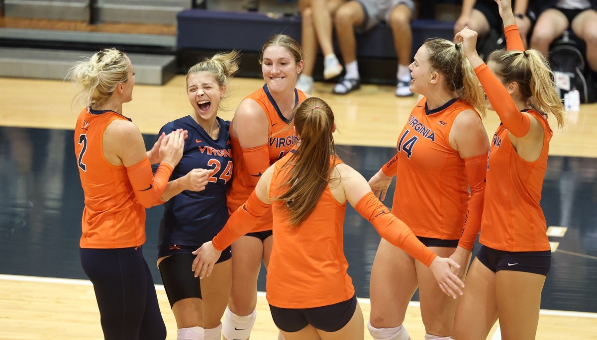 The Virginia volleyball team celebrates after scoring a point against Pittsburgh at Memorial Gymnasium.