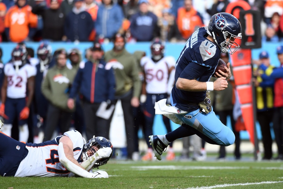 Tennessee Titans quarterback Ryan Tannehill (17) runs for a first down before being tackled by Denver Broncos linebacker Josey Jewell (47) during the first half at Nissan Stadium.