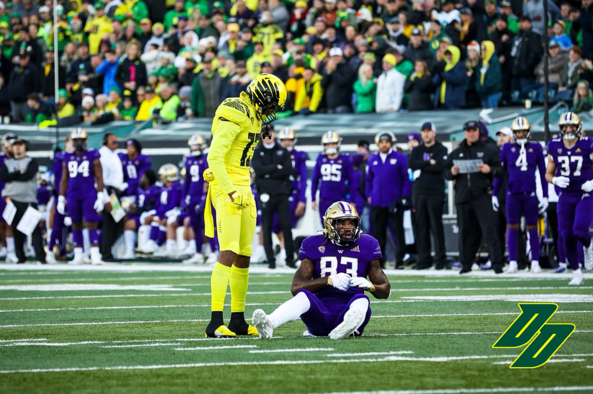 Oregon Ducks safety Bryan Addison stands over Washington Huskies tight end Devin Culp. 