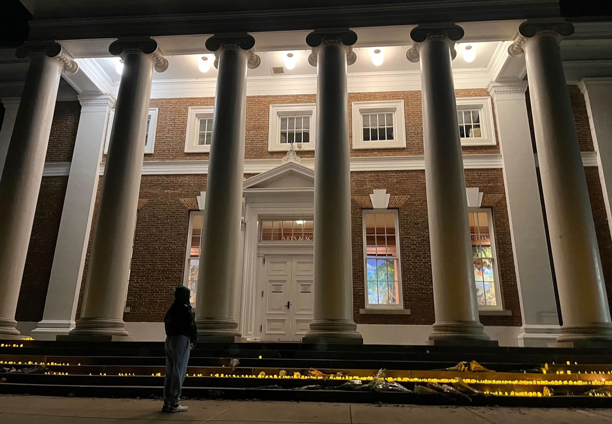 An unidentified student reflects at the steps of Old Cabell Hall, where a vigil was held after an on-campus shooting.