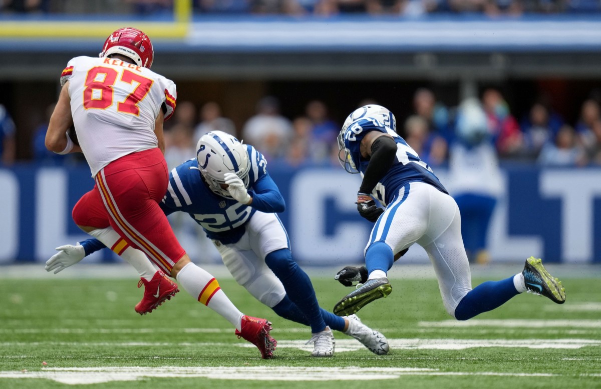 Kansas City Chiefs tight end Travis Kelce (87) evades tackle by Indianapolis Colts safety Rodney Thomas II (25) and safety Rodney McLeod Jr. (26) during a game at Lucas Oil Stadium in Indianapolis.
