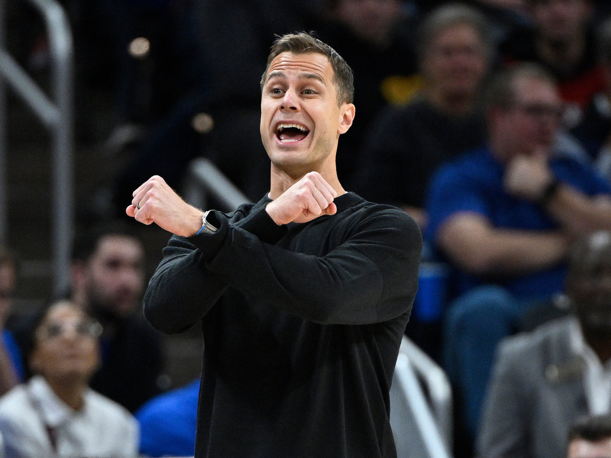 Jon Scheyer makes his arms form an X