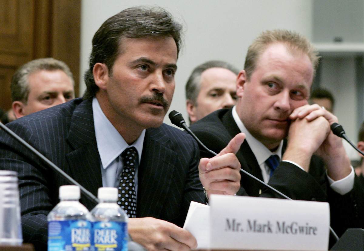 Rafael Palmeiro testifies during a Congressional hearing about the use of steroids in Major League Baseball as Curt Schilling looks on.