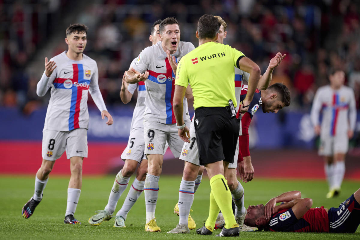Barcelona no.9 Robert Lewandowski pictured (center) complaining to referee Jesus Gil Manzano after being sent off in a game against Osasuna in November 2022