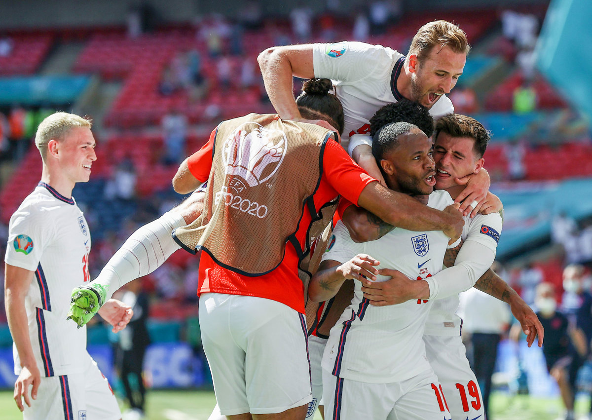 Raheem Sterling is mobbed by England teammates after a goal at Euro 2020