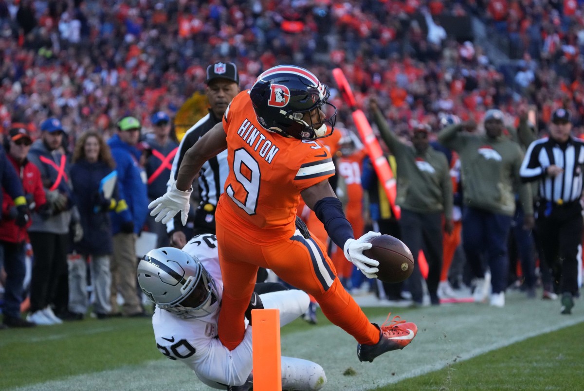 Denver Broncos wide receiver Kendall Hinton (9) reaches for the end zone as Las Vegas Raiders safety Duron Harmon (30) tackles in the first quarter at Empower Field at Mile High.