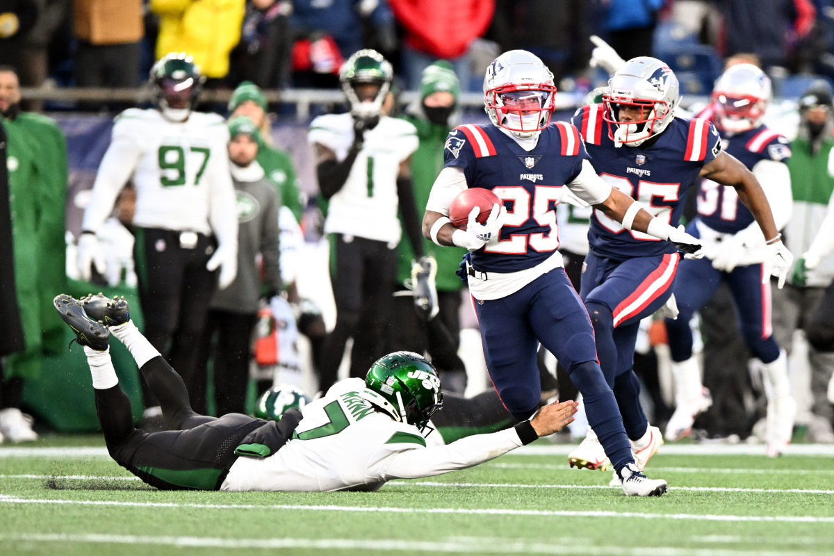 New England Patriots cornerback Marcus Jones (25) runs past New York Jets punter Braden Mann (7) on a return for a touchdown during the second half at Gillette Stadium.