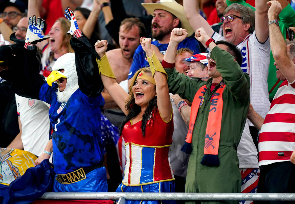 A USA fan dressed as Wonder Woman pictured celebrating in Qatar after seeing Timothy Weah score against Wales at the 2022 World Cup