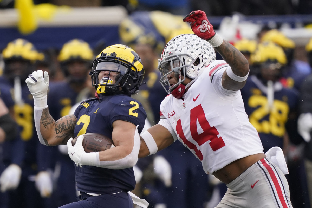 Michigan running back Blake Corum is chased by Ohio State safety Ronnie Hickman in a 2021 game between the two teams.