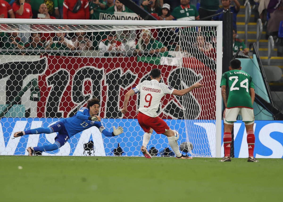 Mexico goalkeeper Guillermo Ochoa pictured diving to save a penalty kick from Poland's Robert Lewandowski at the 2022 FIFA World Cup in Qatar